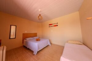 Quarto familiar com decoração praiana na Pousada Costa do Mar, equipado com ar-condicionado e banheiro com água quente. Praia de Peito de Moça, Luís Correia.